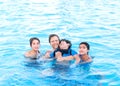 Multiracial family swimming together in pool. Disabled youngest Royalty Free Stock Photo