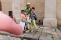 Multiracial family travelling together with small kids. Taking photo in old city cetre.