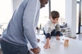 Multiracial father and his caucasian son playing at the domino while communicating Royalty Free Stock Photo