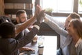 Multiracial friends giving high five sitting out in coffee shop Royalty Free Stock Photo