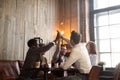 Multiracial friends group giving high five sitting at cafe table Royalty Free Stock Photo