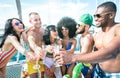 Multiracial friends having fun drinking champagne wine at sail boat party - Friendship concept with young multi racial people Royalty Free Stock Photo