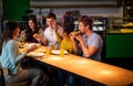 Multiracial friends having fun eating pizza in pizzeria. Royalty Free Stock Photo