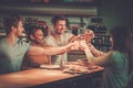 Multiracial friends having fun eating in pizzeria.