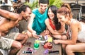 Multiracial friends having fun with mobile smart phone at beach cocktail bar - Young happy people addicted by smartphone Royalty Free Stock Photo
