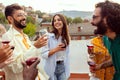 Multiracial friends having fun together at summer party on rooftop terrace Royalty Free Stock Photo