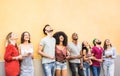 Multiracial friends having fun using smartphone at wall on university college break - Young people addicted by mobile smart phones Royalty Free Stock Photo