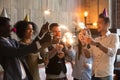 Multiracial friends holding sparklers glasses, celebrating toget Royalty Free Stock Photo