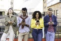 Multiracial friends laughing using smartphone in the university district of the city - Young people addicted by mobile smart Royalty Free Stock Photo