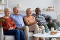 Multiracial friends senior people watching TV in the living room