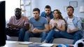 Multiracial friends sitting on couch and comfortably watching sports game on tv Royalty Free Stock Photo