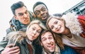 Multiracial best friends taking selfie outdoor on autumn winter clothes - Happy youth concept with millennial people having fun Royalty Free Stock Photo