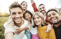 Multiracial friends taking selfie picture with smart mobile phone outside - Group of young people smiling at camera outdoors - Royalty Free Stock Photo