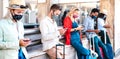 Multiracial friends wearing face mask using mobile smart phones - Young millenial checking online reservations at train station