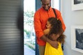 Multiracial girl with curly long hair cuddling young smiling father arrived from work at home Royalty Free Stock Photo