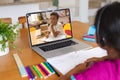 Multiracial girl discussing homework with boy over laptop while studying online on table at home Royalty Free Stock Photo