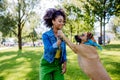 Multiracial girl training her dog outdoor in a city park. Concept of relationship between dog and teenager, everyday Royalty Free Stock Photo