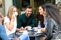 Multiracial group of five friends having a coffee together Royalty Free Stock Photo