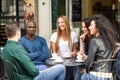 Multiracial group of five friends having a coffee together Royalty Free Stock Photo
