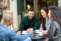 Multiracial group of five friends having a coffee together Royalty Free Stock Photo