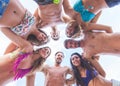 Multiracial group of friends embraced at seaside, bottom view.