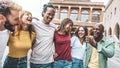 Multiracial group of friends having fun walking on city street - Happy young people hanging outside together on weekend day - Royalty Free Stock Photo