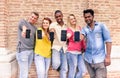 Multiracial group of friends showing blank smartphone screens outdoors - Young multi ethnic people having fun with mobile phones