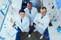 Multiracial group of scientists standing together in chemical lab