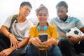 Multiracial group of teen high school classmates sit on stairs looking at teenage girl cell phone Royalty Free Stock Photo