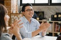 Multiracial group of young creative people in smart casual wear discussing business gesture hand high five, laughing and smiling