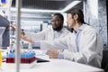 Multiracial laboratory technicians work together to process DNA patient data Royalty Free Stock Photo
