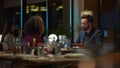 Multiracial lovers chatting together in night restaurant. Couple on dinner date. Royalty Free Stock Photo