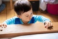 A multiracial Malaysian and Spanish infant wearing blue pajamas looking away with mucus under his nose because he is ill. Touching