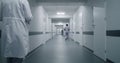 Multiracial medical staff walk clinic corridor