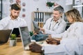 Multiracial medical workers examining results of x ray scan Royalty Free Stock Photo