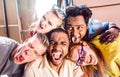 Multiracial millenial people taking selfie sticking out tongue with happy faces - Funny life style concept against racism Royalty Free Stock Photo