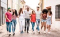 Multiracial millennial friends walking in city center - Happy guys and girls having fun around old town streets Royalty Free Stock Photo