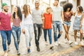 Multiracial millennial friends walking and talking in city center Royalty Free Stock Photo