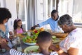 Multiracial multigeneration family holding hands and saying grace before lunch at dining table Royalty Free Stock Photo