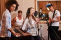 Multiracial music band performing in a recording studio