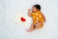 Multiracial newborn baby sleep and lie on bed new notebook with red heart model with day light in concept of happiness sweet dream