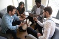 Multiethnic workers sitting in circle using diverse mobile gadgets Royalty Free Stock Photo