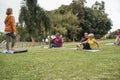 Multiracial people doing yoga class outdoor in city park - Focus on african woman face Royalty Free Stock Photo