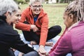 Multiracial people stacking hands outdoor at city park - Focus on center senior face