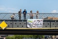 Multiracial people stand on bridge with protest demonstration action holding poster Treat all refugees like they were