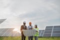 Multiracial people standing outdoors with plan of solar farm Royalty Free Stock Photo