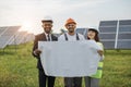 Multiracial people standing outdoors with plan of solar farm Royalty Free Stock Photo