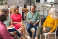 Multiracial senior men and women discussing during group therapy session