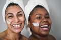 Multiracial senior and young women doing beauty treatment using skin masks - Body care concept - Focus on african woman eye