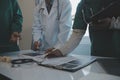 Multiracial team of doctors discussing a patient standing grouped in the foyer looking at a tablet computer, close up view Royalty Free Stock Photo